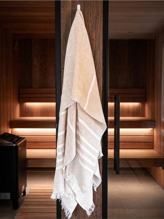 Hamamhåndkle i 100 % lin i naturfarge med striper hengende utenfor badstue