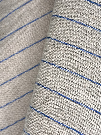 Nærbilde av kjøkkenhåndkle i naturfarge med brede blå striper, tekstur av ubehandlet lin.