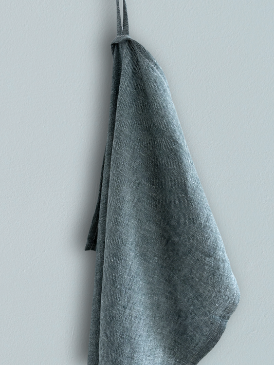 Kjøkkenhåndkle i 100 % lin i støvgrønn farge hengt på vegg.